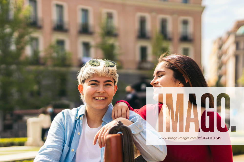 IMAGO Creative: Sommer, Sommertage im Stadtpark two teenager girls laughing and smiling sitting on a bench Model Released PedroMerino_ID18689_556834_027