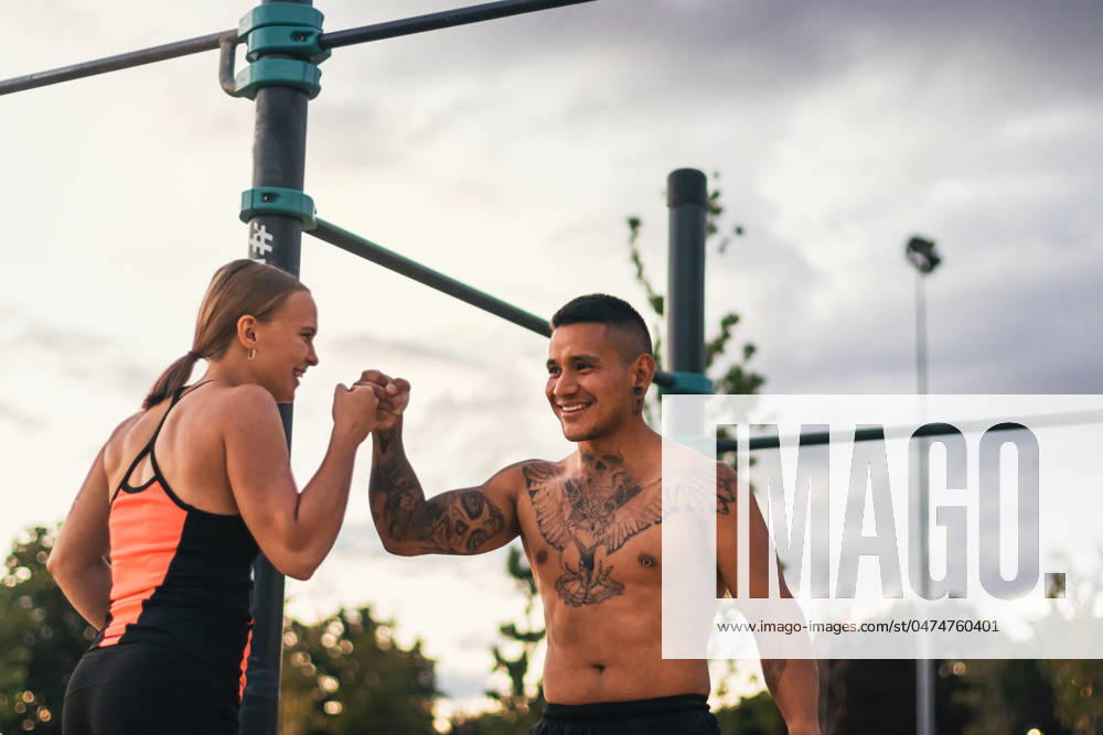 IMAGO Creative: Sommer, Sommertage im Stadtpark interracial couple training outdoors. fist bumping Model Released PedroMerino_ID18885_562306_003