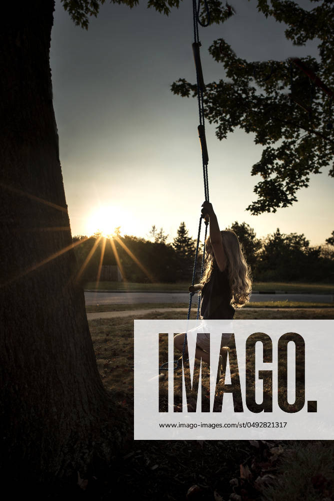 IMAGO Creative, Jahreszeit Sommer, Sommerferien Little girl long blonde curls swinging in bright sunlight Wooster, Ohio, United States CR_JOKU240509-1420068-01 ,model released, Symbolfoto