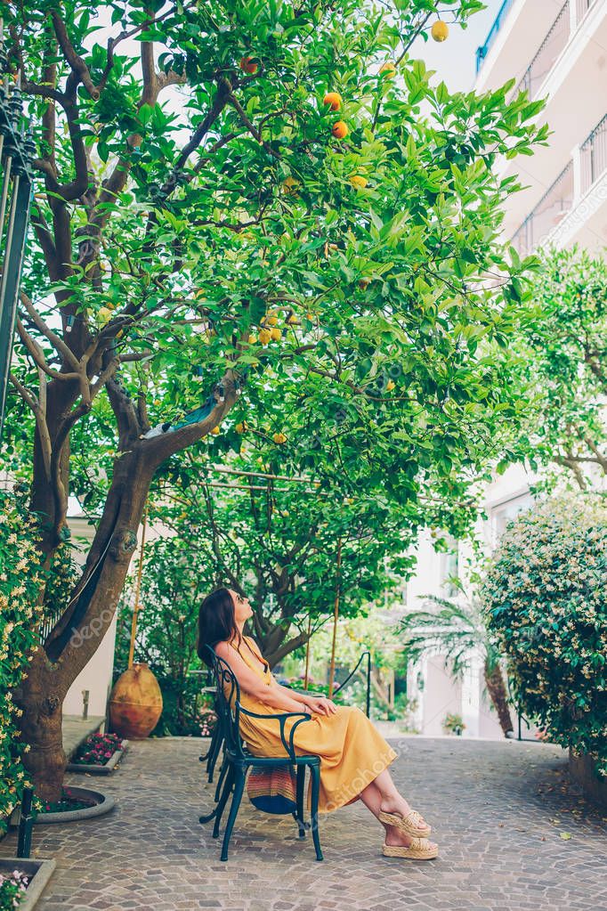 Woman in yellow dress in lemon garden of Sorrento at summer model released