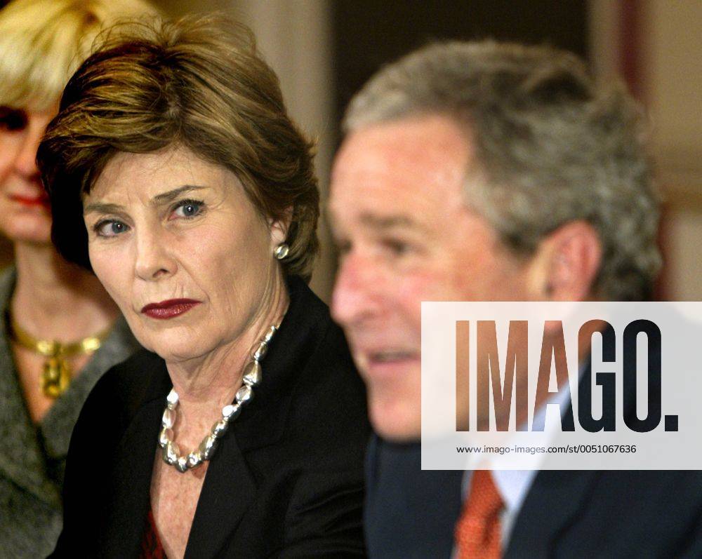 First Lady Laura Bush (li.) betrachtet konzentriert ihren Ehemann Präsident George W. Bush (beide USA) während eines Gespräches mit Sonderbeauftragten über den Wiederaufbau der Golfküste nach den Wirbelstürmen im Weißen Haus in Washington D.C. wax2006011901