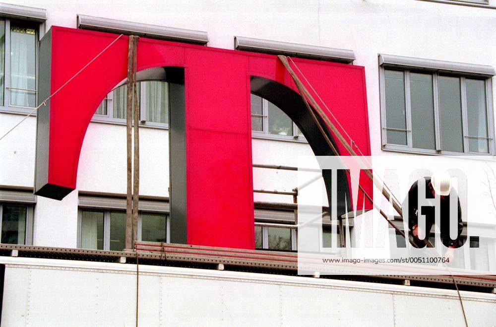T-Logo der Deutschen Telekom wird auf dem Dach eines Firmengebäudes befestigt