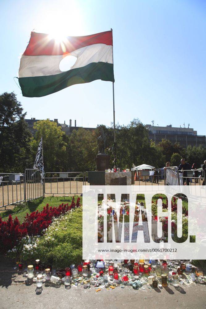 Ungarische Nationalflagge mit herausgeschnittenem Wappen sowie zahlreiche Kerzen am Mahnmal der Volksaufstände von 1956 anlässlich von Demonstrationen gegen die ungarische Regierung in Budapest - iblfgu00135606