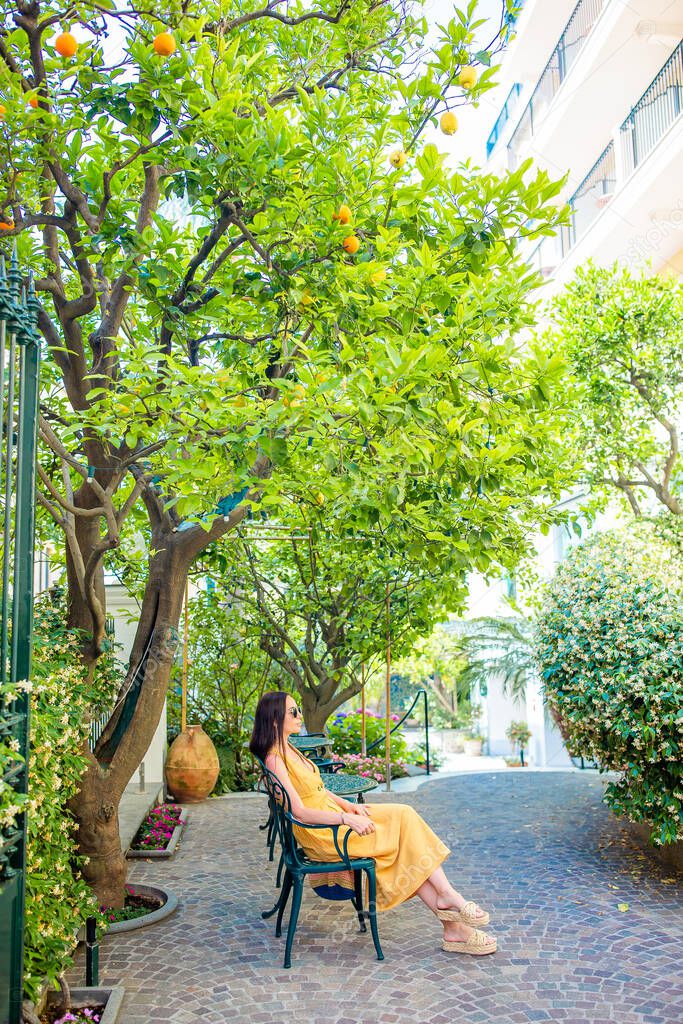 Woman in yellow dress in lemon garden of Sorrento at summer in Italy model released