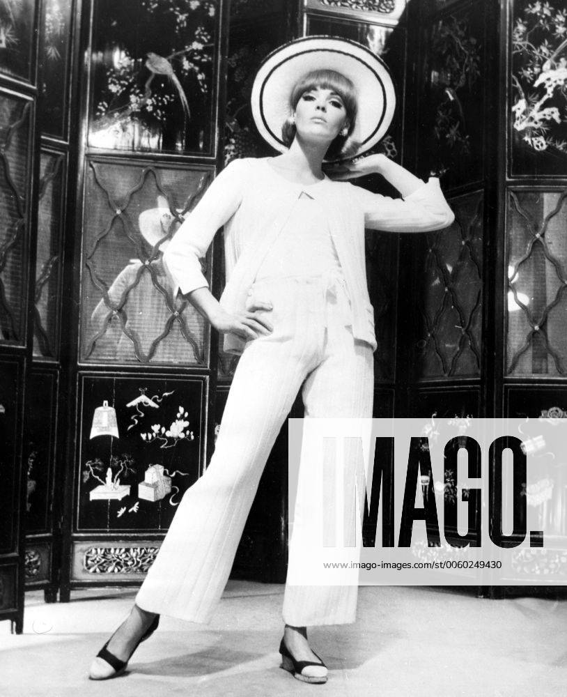 IMAGO ICONS: Coco Chanel Pure white ribbed silk and wool fabric for a pyjama suit with the skimmy look and pants widening at the hem presented by Chanel for summer resorts wear at fashion show on 9th April 1965 UnitedArchives01230269