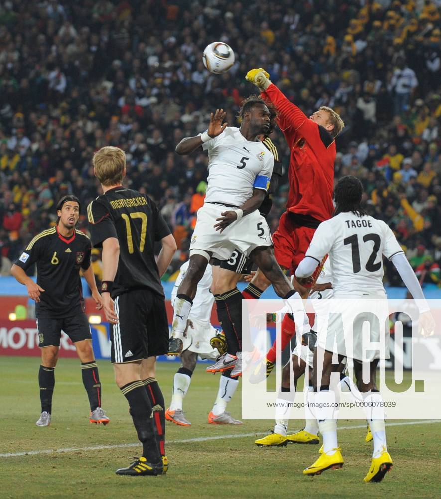 Goalkeeper Manuel Neuer of Germany punches clear under pressure from John Mensah (5) of Ghana - Group D, Ghana vs Germany - .