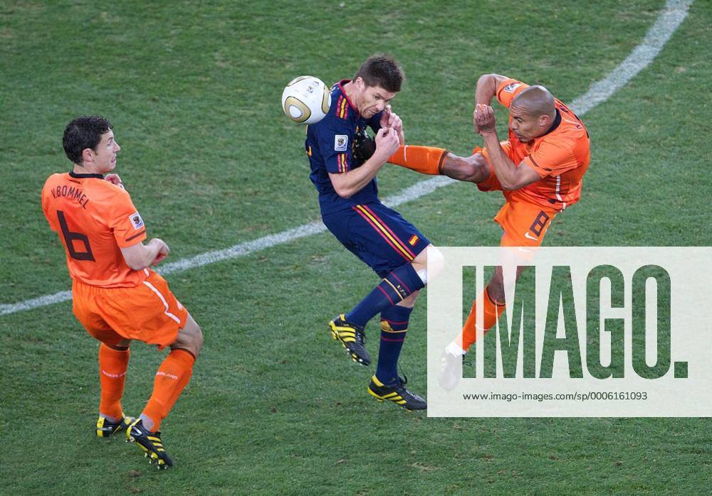 Football - 2010 FIFA World Cup - Final - Spain vs. Netherlands Nigel de Jong (R) of the Netherlands kicks Xabi Alonso (C) of Spain in the chest earning himself a yellow card next to Mark van Bommel (L) of Netherlands at Soccer City Stadium, Johannesburg o0 Foulspiel, gefoult, Härte, Kampf, Tritt brutal Brutalität