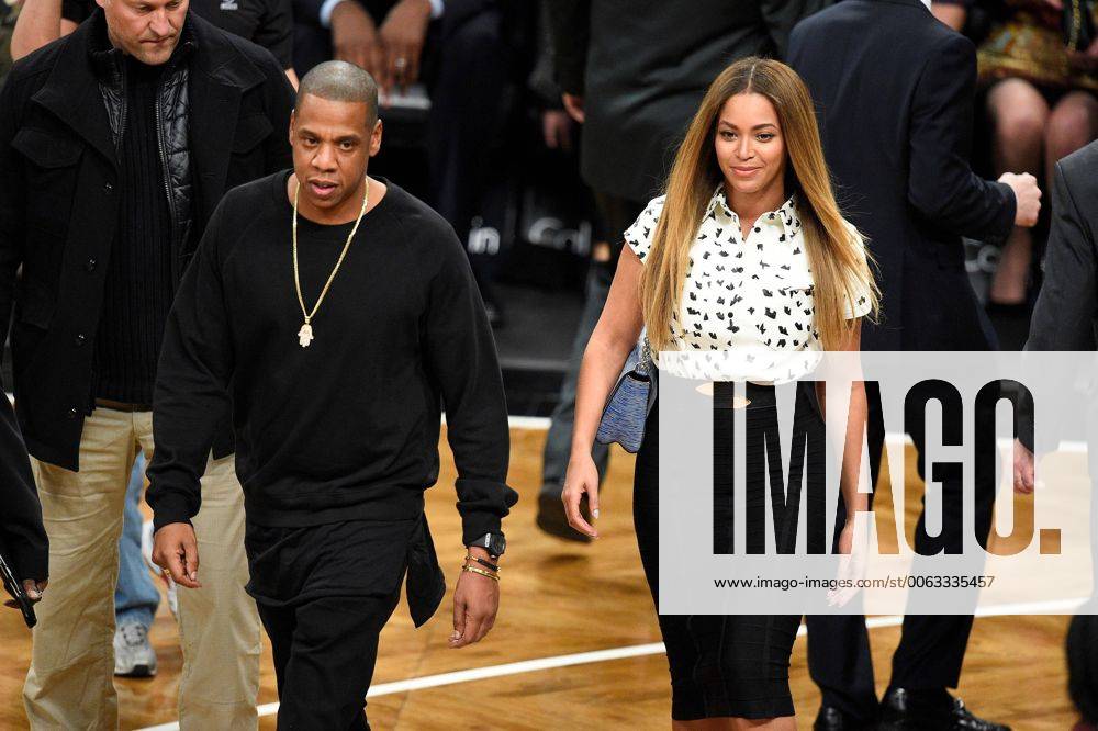 Jay Z and Beyonce walk back to their seats after greeting Brooklyn Nets play the Cleveland Cavaliers at Barclays Center in New York City on December 8, 2014. NYP20141209121