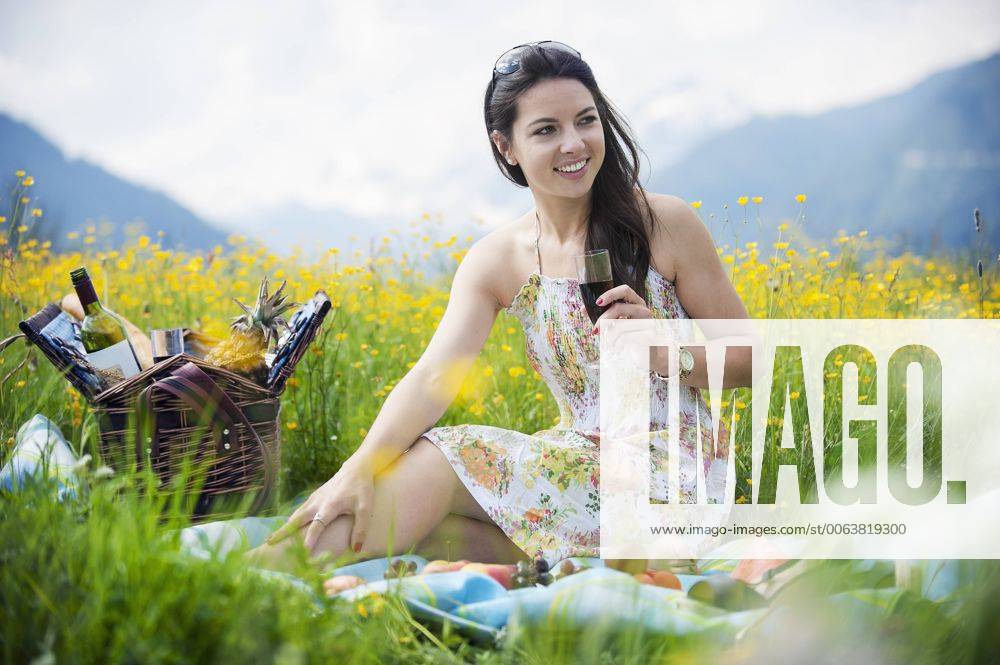 Young woman having picnic on alpine meadow model released Symbolfoto HHF005050