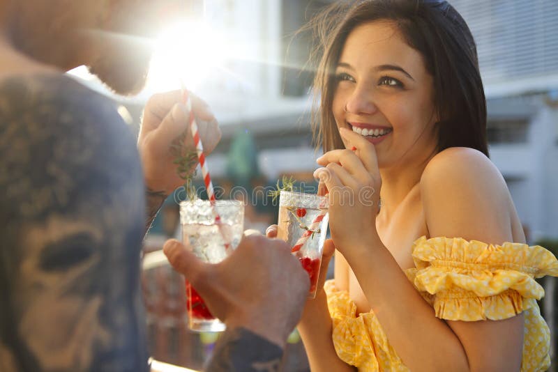 Couple in love drinking summer refreshing lemonade with rasberry on a balcony, Happy couple in love drinking summer refreshing lemonade with rasberry on a balcony