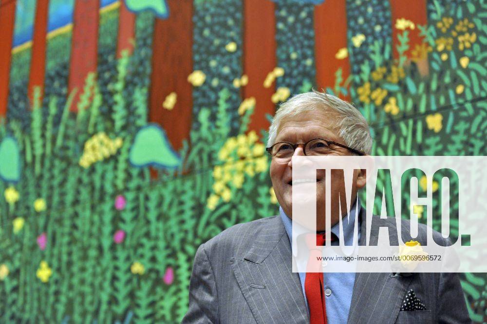 Jan. 16, 2012 - London, England, United Kingdom - Artist DAVID HOCKNEY poses with his painting The Arrival Of Spring In Woldgate, East Yorkshire in 2011. The Royal Academy of Arts will showcase the first major exhibition of new landscape works by Hockney, more than 150 pieces, mostly from the past decade. Interest has overwhelmed the Academy s online ticket sales site. - ZUMAl94_