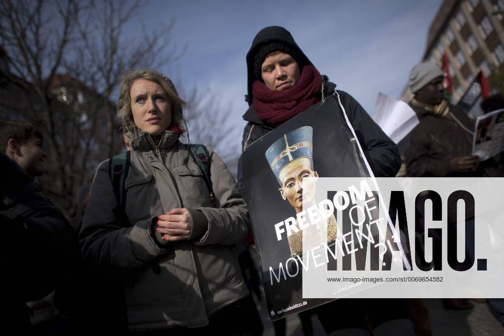 Gedenkmarsch Kolonialgeschichte DEU, Deutschland, Germany, Berlin, 27.02.2016 Demonstrant mit Plakat Freedom of Movement und Foto der Nofretete gegen die Kolobialgeschichte und die Aneigung afrikanischer Kulturgueter durch deutsche Museen und dem Humboldt Forum beim 10. Gedenkmarsch zur Erinnerung an die afrikanischen Opfer von Versklavung, Kolonialismus und rassistischer Gewalt vom Komitee fuer ein afrikanisches Denkmal in Berlin und afrikanischer Vereine in Berlin. Dieser Gedenkmarsch wurde ins Leben gerufen, um der Forderung nach Anerkennung der Verbrechen gegen Schwarze Menschen und Menschen afrikanischer Herkunft Nachdruck zu verleihen. Anlass ist die Berliner Afrika-Konferenz von 1884 - 1885, auf der Afrika vor 130 Jahren unter den europaeischen Kolonialmaechten aufgeteilt wurde. Mehr als 30 Millionen Afrikanerinnen und Afrikaner wurden Opfer von Versklavung und kolonialen Verbrech