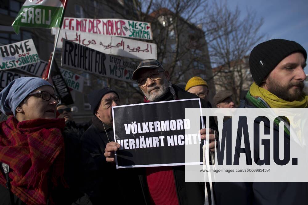 Gedenkmarsch Kolonialgeschichte DEU, Deutschland, Germany, Berlin, 27.02.2016 Demonstranten mit Plakat Voelkermord verjaehrt nicht und Set them Free beim 10. Gedenkmarsch zur Erinnerung an die afrikanischen Opfer von Versklavung, Kolonialismus und rassistischer Gewalt vom Komitee fuer ein afrikanisches Denkmal in Berlin und afrikanischer Vereine in Berlin. Dieser Gedenkmarsch wurde ins Leben gerufen, um der Forderung nach Anerkennung der Verbrechen gegen Schwarze Menschen und Menschen afrikanischer Herkunft Nachdruck zu verleihen. Anlass ist die Berliner Afrika-Konferenz von 1884 - 1885, auf der Afrika vor 130 Jahren unter den europaeischen Kolonialmaechten aufgeteilt wurde. Mehr als 30 Millionen Afrikanerinnen und Afrikaner wurden Opfer von Versklavung und kolonialen Verbrechen gegen die Menschlichkeit. Die von Deutschland an den Herero und Nama begangenen Voelkermorde in Namibia und di