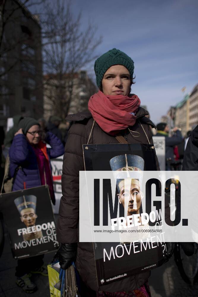 Gedenkmarsch Kolonialgeschichte DEU, Deutschland, Germany, Berlin, 27.02.2016 Demonstrant mit Plakat Freedom of Movement und Foto der Nofretete gegen die Kolobialgeschichte und die Aneigung afrikanischer Kulturgueter durch deutsche Museen und dem Humboldt Forum beim 10. Gedenkmarsch zur Erinnerung an die afrikanischen Opfer von Versklavung, Kolonialismus und rassistischer Gewalt vom Komitee fuer ein afrikanisches Denkmal in Berlin und afrikanischer Vereine in Berlin. Dieser Gedenkmarsch wurde ins Leben gerufen, um der Forderung nach Anerkennung der Verbrechen gegen Schwarze Menschen und Menschen afrikanischer Herkunft Nachdruck zu verleihen. Anlass ist die Berliner Afrika-Konferenz von 1884 - 1885, auf der Afrika vor 130 Jahren unter den europaeischen Kolonialmaechten aufgeteilt wurde. Mehr als 30 Millionen Afrikanerinnen und Afrikaner wurden Opfer von Versklavung und kolonialen Verbrech