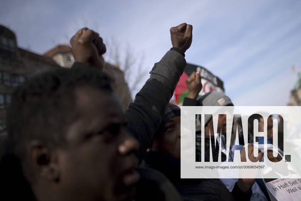 Gedenkmarsch Kolonialgeschichte DEU, Deutschland, Germany, Berlin, 27.02.2016 Demonstranten afrikanischer Herrkunft mit geballter Faust beim Singen der suedafrikanischen Hymne beim 10. Gedenkmarsch zur Erinnerung an die afrikanischen Opfer von Versklavung, Kolonialismus und rassistischer Gewalt vom Komitee fuer ein afrikanisches Denkmal in Berlin und afrikanischer Vereine in Berlin. Dieser Gedenkmarsch wurde ins Leben gerufen, um der Forderung nach Anerkennung der Verbrechen gegen Schwarze Menschen und Menschen afrikanischer Herkunft Nachdruck zu verleihen. Anlass ist die Berliner Afrika-Konferenz von 1884 - 1885, auf der Afrika vor 130 Jahren unter den europaeischen Kolonialmaechten aufgeteilt wurde. Mehr als 30 Millionen Afrikanerinnen und Afrikaner wurden Opfer von Versklavung und kolonialen Verbrechen gegen die Menschlichkeit. Die von Deutschland an den Herero und Nama begangenen Voe