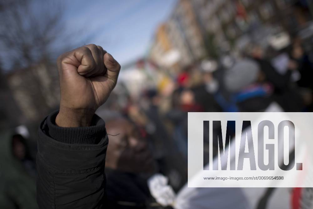 Gedenkmarsch Kolonialgeschichte DEU, Deutschland, Germany, Berlin, 27.02.2016 Demonstranten afrikanischer Herrkunft mit geballter Faust beim Singen der suedafrikanischen Hymne beim 10. Gedenkmarsch zur Erinnerung an die afrikanischen Opfer von Versklavung, Kolonialismus und rassistischer Gewalt vom Komitee fuer ein afrikanisches Denkmal in Berlin und afrikanischer Vereine in Berlin. Dieser Gedenkmarsch wurde ins Leben gerufen, um der Forderung nach Anerkennung der Verbrechen gegen Schwarze Menschen und Menschen afrikanischer Herkunft Nachdruck zu verleihen. Anlass ist die Berliner Afrika-Konferenz von 1884 - 1885, auf der Afrika vor 130 Jahren unter den europaeischen Kolonialmaechten aufgeteilt wurde. Mehr als 30 Millionen Afrikanerinnen und Afrikaner wurden Opfer von Versklavung und kolonialen Verbrechen gegen die Menschlichkeit. Die von Deutschland an den Herero und Nama begangenen Voe
