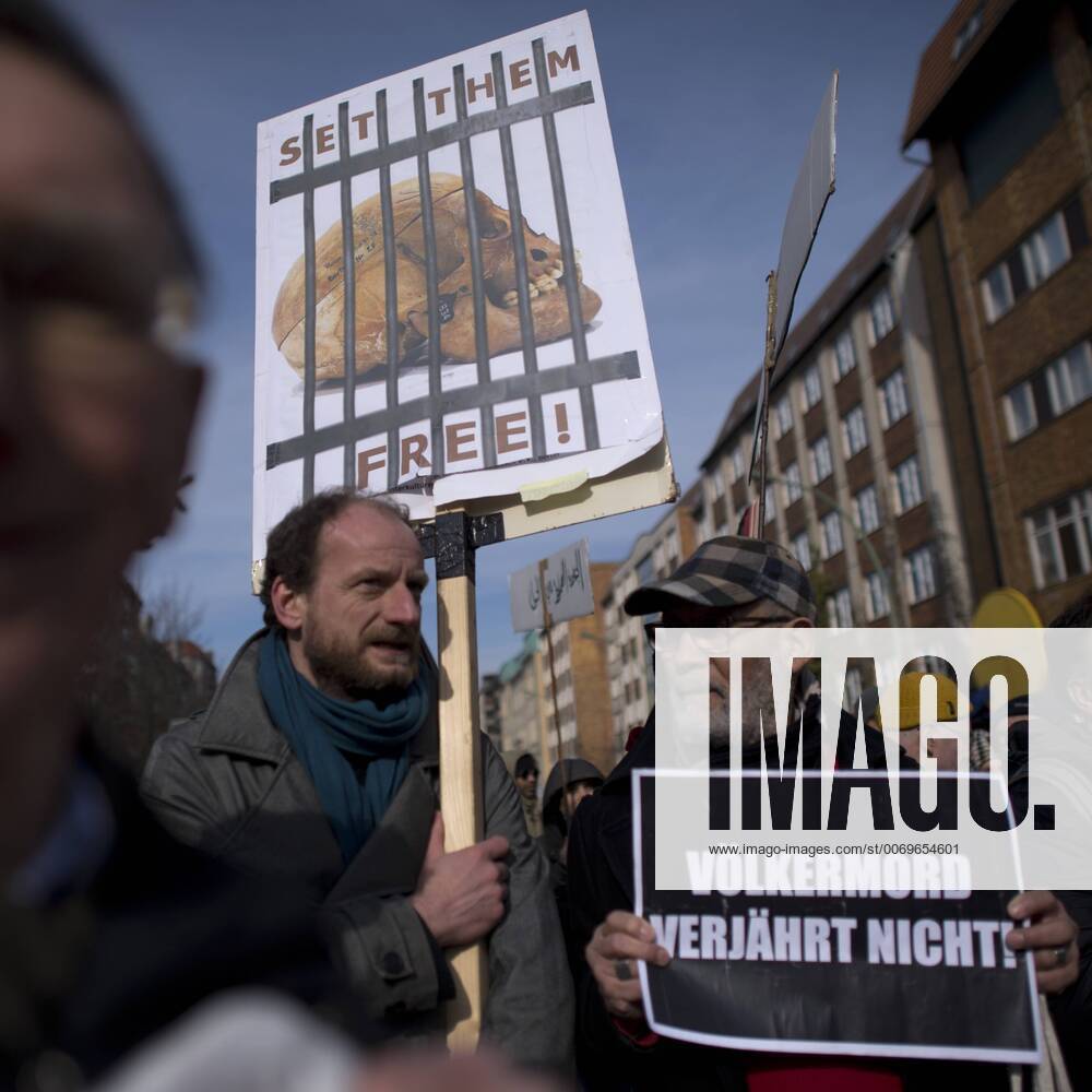 Gedenkmarsch Kolonialgeschichte DEU, Deutschland, Germany, Berlin, 27.02.2016 Demonstranten mit Plakat Voelkermord verjaehrt nicht und Set them Free beim 10. Gedenkmarsch zur Erinnerung an die afrikanischen Opfer von Versklavung, Kolonialismus und rassistischer Gewalt vom Komitee fuer ein afrikanisches Denkmal in Berlin und afrikanischer Vereine in Berlin. Dieser Gedenkmarsch wurde ins Leben gerufen, um der Forderung nach Anerkennung der Verbrechen gegen Schwarze Menschen und Menschen afrikanischer Herkunft Nachdruck zu verleihen. Anlass ist die Berliner Afrika-Konferenz von 1884 - 1885, auf der Afrika vor 130 Jahren unter den europaeischen Kolonialmaechten aufgeteilt wurde. Mehr als 30 Millionen Afrikanerinnen und Afrikaner wurden Opfer von Versklavung und kolonialen Verbrechen gegen die Menschlichkeit. Die von Deutschland an den Herero und Nama begangenen Voelkermorde in Namibia und di