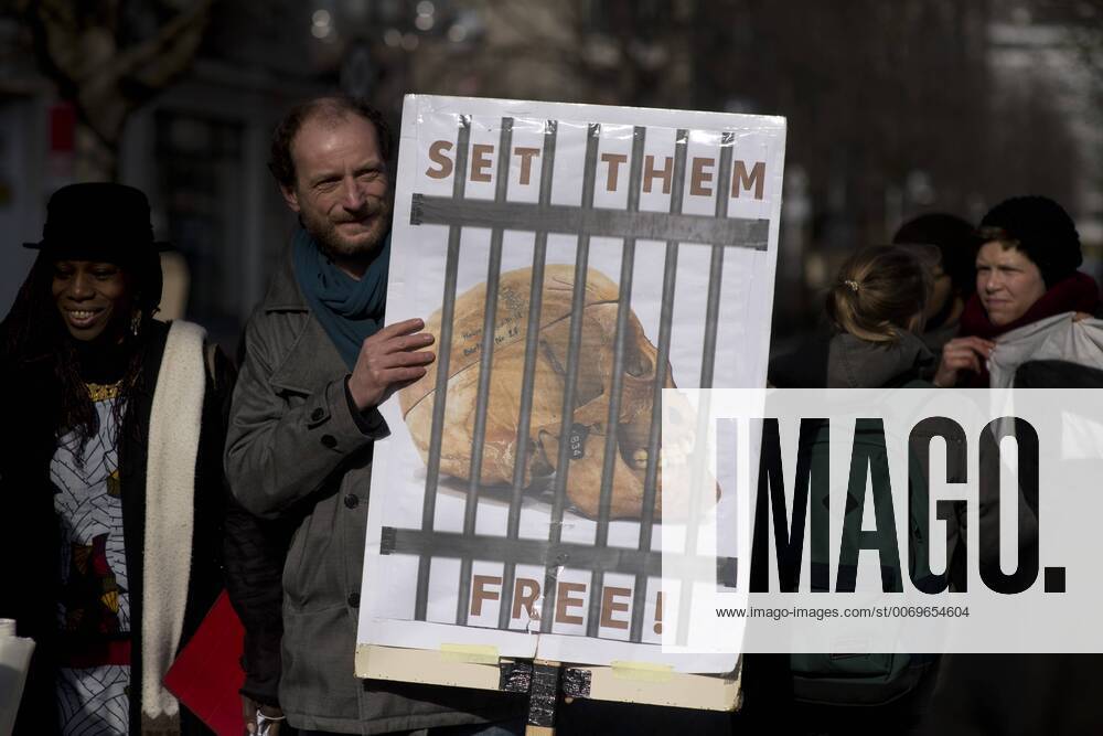 Gedenkmarsch Kolonialgeschichte DEU, Deutschland, Germany, Berlin, 27.02.2016 Demonstranten mit Plakat Voelkermord verjaehrt nicht und Set them Free beim 10. Gedenkmarsch zur Erinnerung an die afrikanischen Opfer von Versklavung, Kolonialismus und rassistischer Gewalt vom Komitee fuer ein afrikanisches Denkmal in Berlin und afrikanischer Vereine in Berlin. Dieser Gedenkmarsch wurde ins Leben gerufen, um der Forderung nach Anerkennung der Verbrechen gegen Schwarze Menschen und Menschen afrikanischer Herkunft Nachdruck zu verleihen. Anlass ist die Berliner Afrika-Konferenz von 1884 - 1885, auf der Afrika vor 130 Jahren unter den europaeischen Kolonialmaechten aufgeteilt wurde. Mehr als 30 Millionen Afrikanerinnen und Afrikaner wurden Opfer von Versklavung und kolonialen Verbrechen gegen die Menschlichkeit. Die von Deutschland an den Herero und Nama begangenen Voelkermorde in Namibia und di