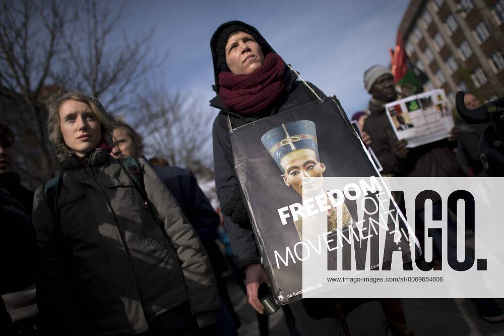 Gedenkmarsch Kolonialgeschichte DEU, Deutschland, Germany, Berlin, 27.02.2016 Demonstrant mit Plakat Freedom of Movement und Foto der Nofretete gegen die Kolobialgeschichte und die Aneigung afrikanischer Kulturgueter durch deutsche Museen und dem Humboldt Forum beim 10. Gedenkmarsch zur Erinnerung an die afrikanischen Opfer von Versklavung, Kolonialismus und rassistischer Gewalt vom Komitee fuer ein afrikanisches Denkmal in Berlin und afrikanischer Vereine in Berlin. Dieser Gedenkmarsch wurde ins Leben gerufen, um der Forderung nach Anerkennung der Verbrechen gegen Schwarze Menschen und Menschen afrikanischer Herkunft Nachdruck zu verleihen. Anlass ist die Berliner Afrika-Konferenz von 1884 - 1885, auf der Afrika vor 130 Jahren unter den europaeischen Kolonialmaechten aufgeteilt wurde. Mehr als 30 Millionen Afrikanerinnen und Afrikaner wurden Opfer von Versklavung und kolonialen Verbrech