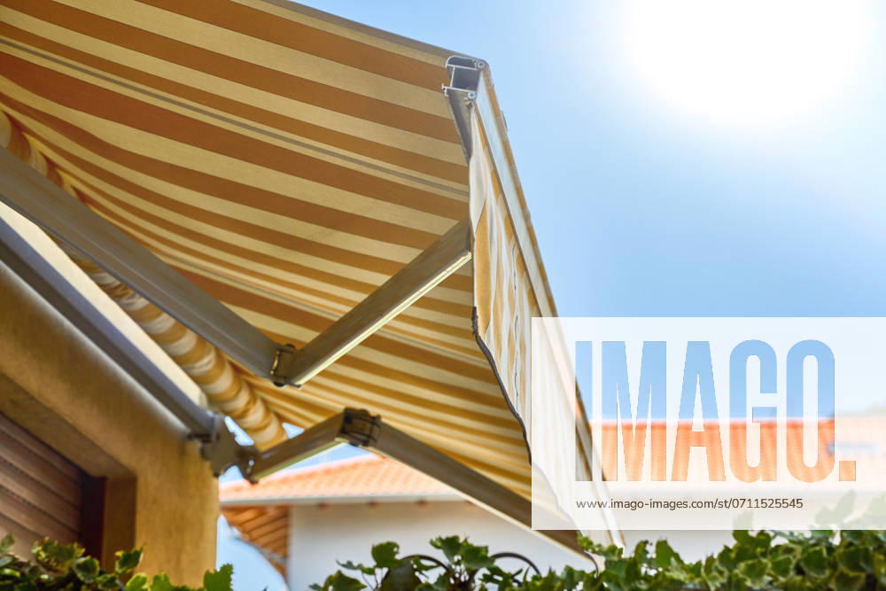 IMAGO Creative, Jahreszeit Sommer, Hitze Nago-Torbole, Lake Garda, Italy - 15 July 2024: Awning on a vacation apartment on Lake Garda offers optimum sun protection and increases outdoor living comfort. Awning provides pleasant shade and a cozy ambience on the terrace in Italy