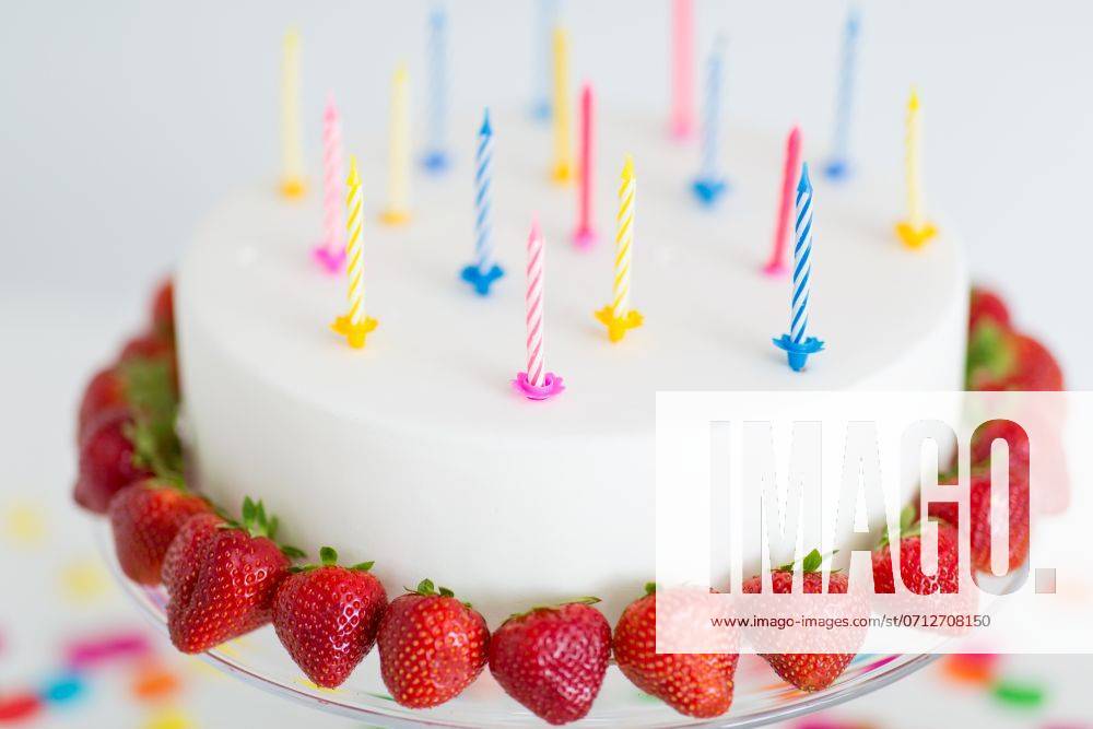 Food, dessert and party concept - close up of birthday cake with candles and strawberries on stand. close up of birthday cake with candles on stand ,model released, Symbolfoto