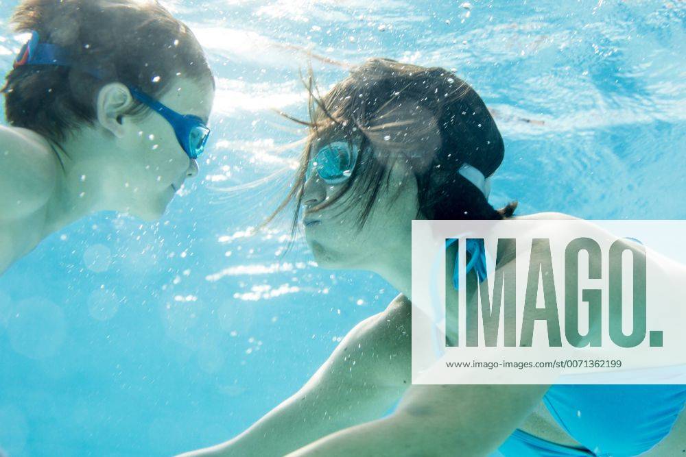 Boy diving underwater with his mum, swimming pool model released Symbolfoto ZOCF000070