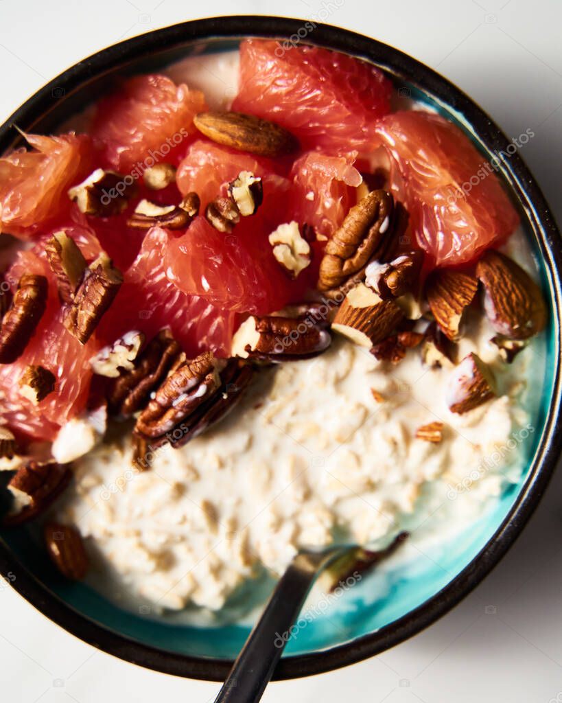 IMAGO Creative, Food, High Protein Frühstück Overnight oats with milk and greek yogurt ingredients list. healthy breakfast with nuts with grapefruit, honey and cinnamon. Top view. High quality photo