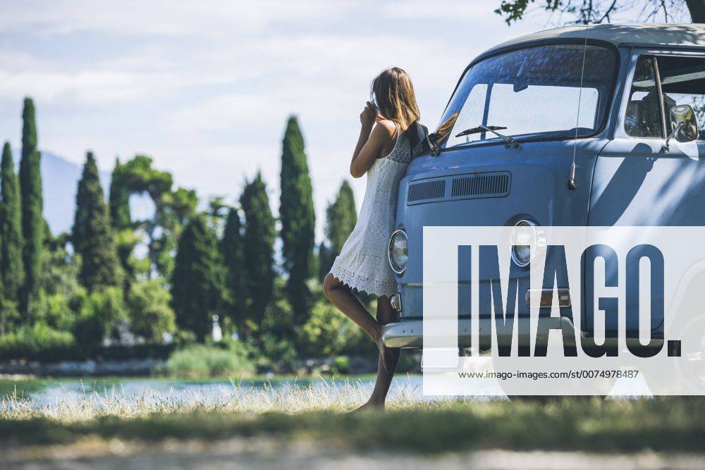Italy, Lake Garda, young woman drinking coffee at camping bus model released Symbolfoto SBOF00287