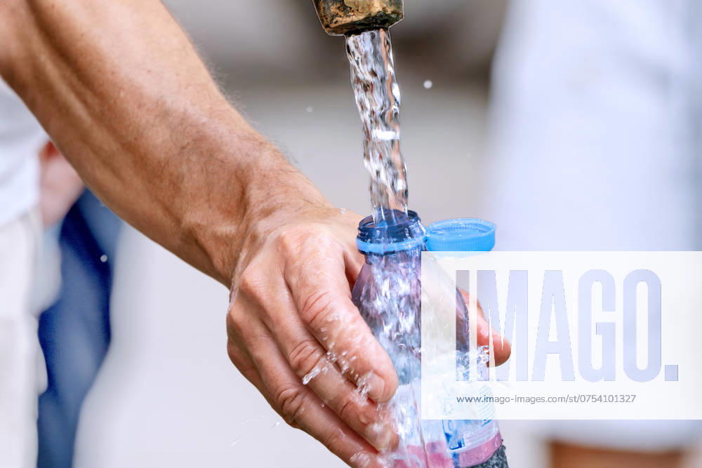 Man fills his water bottle with fresh drinking water, fountain at Marienplatz, midsummer, Munich, August 2024 Germany, Munich, August 2024, a man fills his water bottle with fresh drinking water at the fountain, drinking is particularly important i