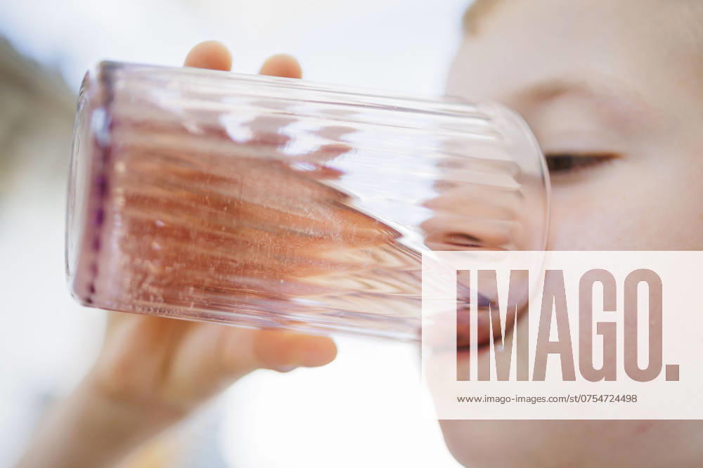 Symbolic photo about drinking water in high temperatures A boy drinks a glass of water in hot summer weather Ziegenrueck, 20 07 2024 Ziegenrueck Germany