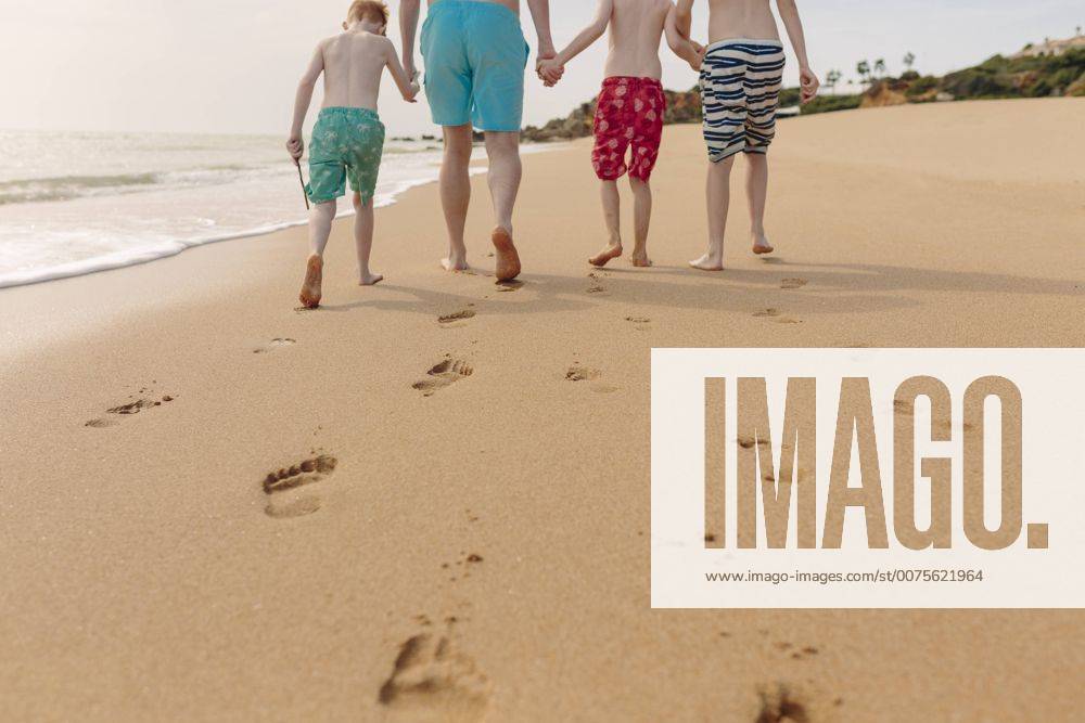 Father and sons walking on the beach model released Symbolfoto NMSF00002