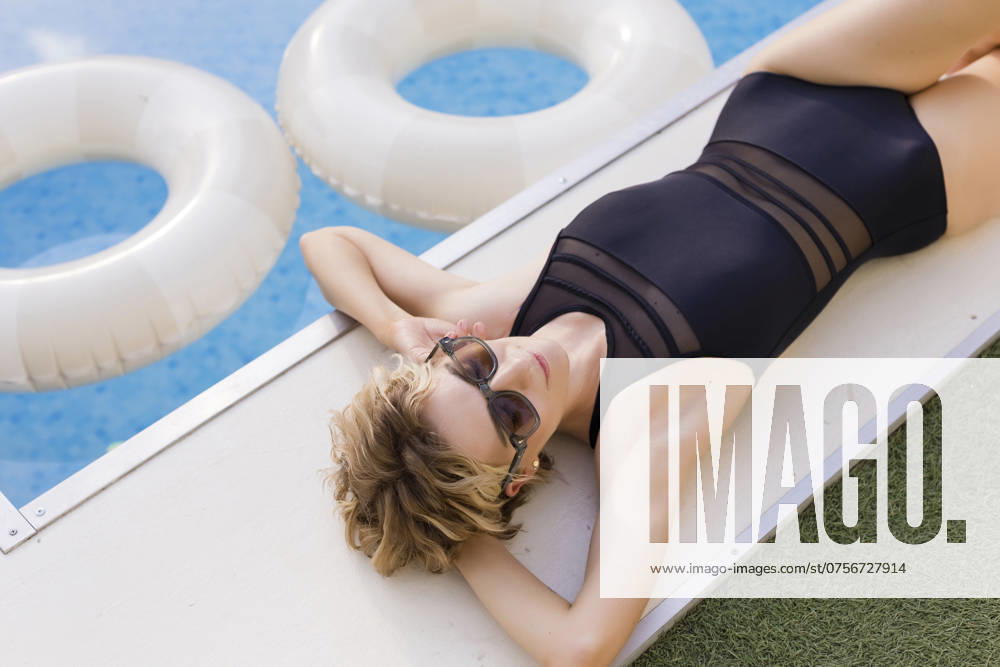 Woman wearing swimsuit and relaxing near swimming pool model released, Symbolfoto property released, ONAF00968