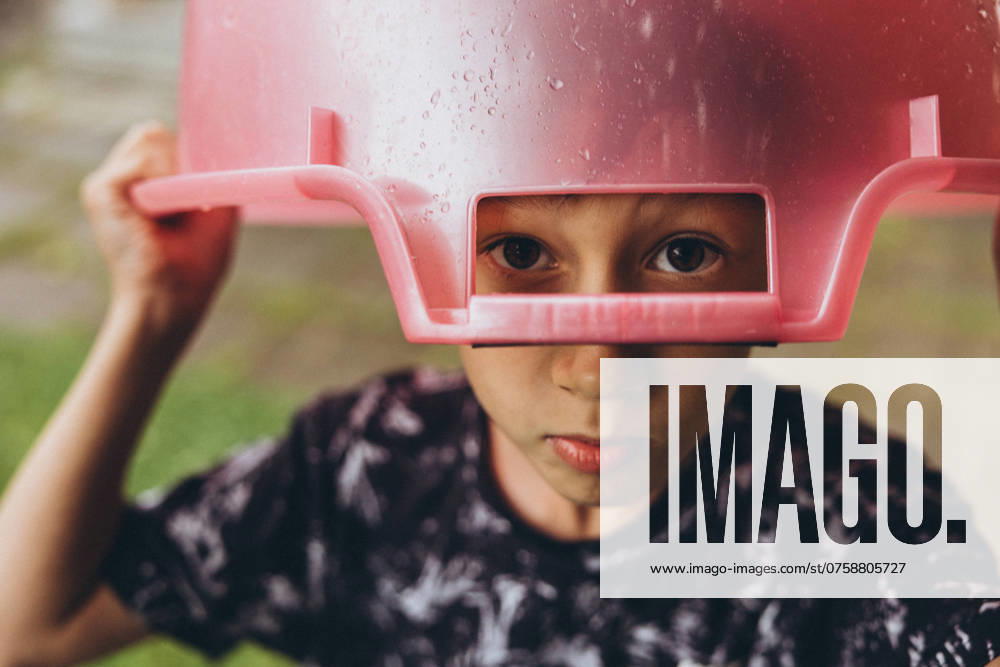 The child uses a bowl instead of an umbrella in rainy weather Moscow, Moscow, Russia CR_ITUP240829-1524349-01 ,model released, Symbolfoto