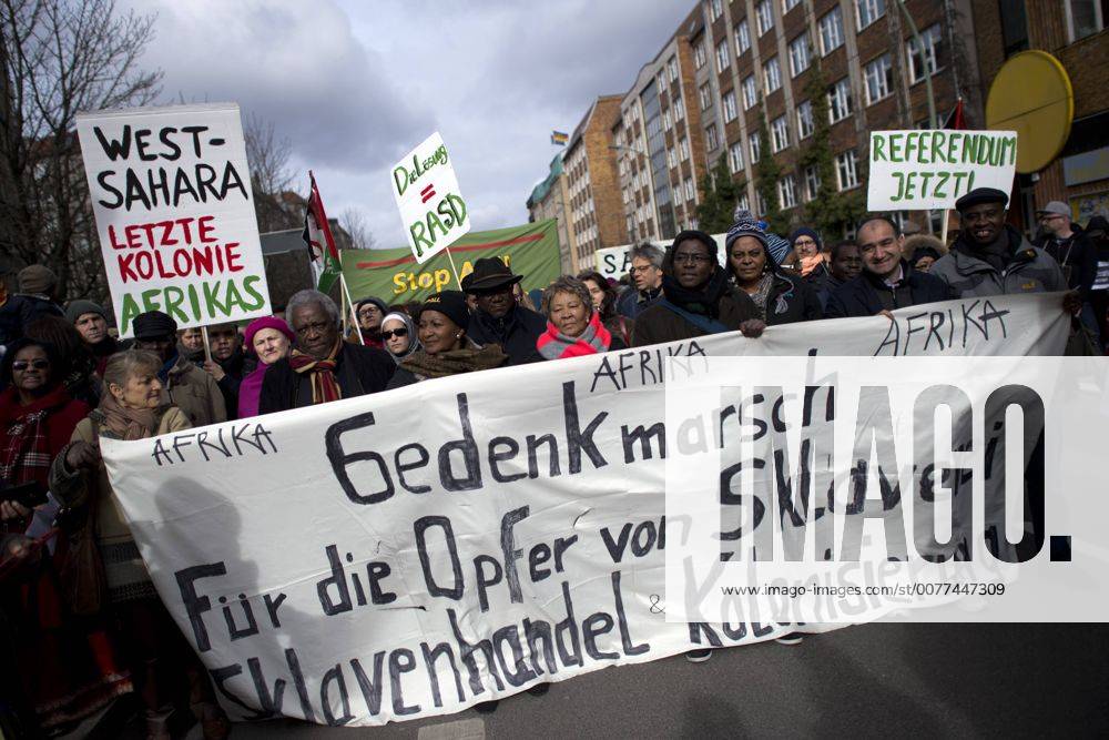 Gedenkmarsch Kolonialgeschichte DEU, Deutschland, Germany, Berlin, 25.02.2017 Demonstranten mit Transparent beim 11. Gedenkmarsch zur Erinnerung an die afrikanischen Opfer von Versklavung, Kolonialismus und rassistischer Gewalt vom Komitee fuer ein afrikanisches Denkmal in Berlin und afrikanischer Vereine in Berlin. Dieser Gedenkmarsch wurde ins Leben gerufen, um der Forderung nach Anerkennung der Verbrechen gegen Schwarze Menschen und Menschen afrikanischer Herkunft Nachdruck zu verleihen. Anlass ist die Berliner Afrika-Konferenz von 1884 - 1885, auf der Afrika vor 130 Jahren unter den europaeischen Kolonialmaechten aufgeteilt wurde. Mehr als 30 Millionen Afrikanerinnen und Afrikaner wurden Opfer von Versklavung und kolonialen Verbrechen gegen die Menschlichkeit. Die von Deutschland an den Herero und Nama begangenen Voelkermorde in Namibia und die Kriegsverbrechen in Tansania im Maji- M