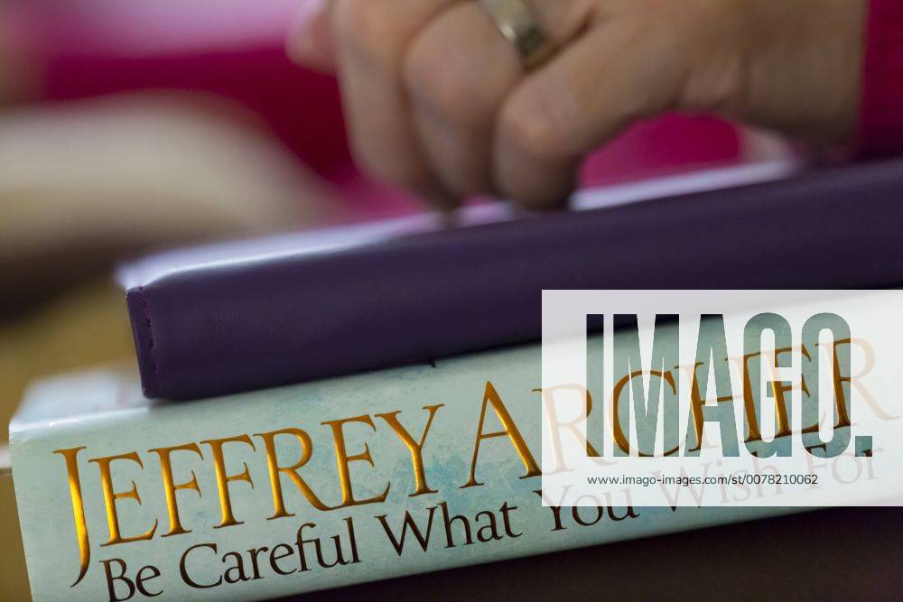 A woman s hand on an iPad and book.
