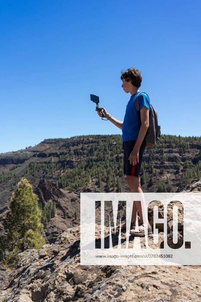 A teenager uses a three-axis image stabilizer to film a natural mountain landscape on a smartphone camera. Gran Canaria. Canary Islands. Spain., A teenager uses a three-axis image stabilizer to film a natural mountain landscape on a smartphone camera. Gran Canaria. Canary Islands. Spain., A teenager uses a three-axis image stabilizer to film a natural mountain landscape on a smartphone camera. Gran Canaria. Canary Islands. Spain. model released, Symbolfoto , 27.09.2024,
