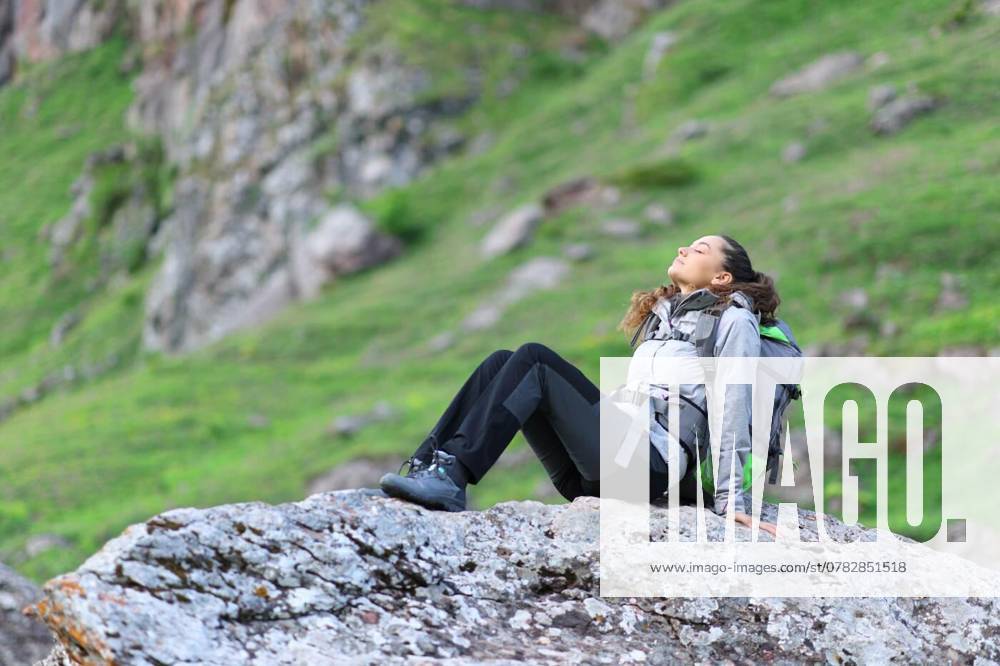 Hiker resting and breathing sitting in nature, Hiker resting and breathing sitting on a rock in nature, Hiker resting and breathing sitting on a rock in nature model released, Symbolfoto , 05.11.2024,
