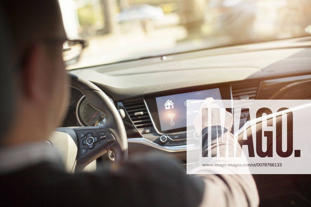 IMAGO Creative: Corporate: Klimaschutz, Digitalisierung und Urbanisierung Man in car adjusting devices at home via smartphone model released Symbolfoto property released NAF00087