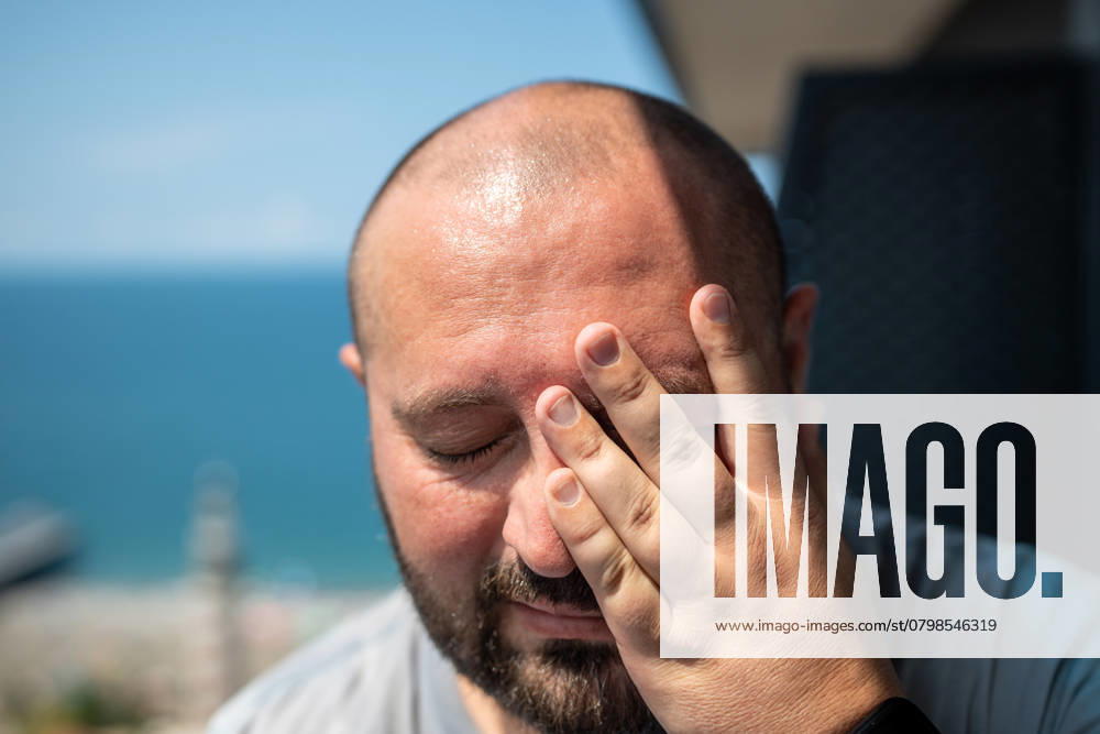 IMAGO Creative, Gesellschaft, Leisure Sickness Porträt eines übergewichtigen Mannes, der an Hyperhidrose leidet und bei heißem Sommerwetter stark schwitzt. Portrait of overweight man suffering hyperhidrosis, high sweating in summer hot weather. Fat bearded guy rubs face with closed eyes stands on balcony. Excess unhealthy body weight. ,model released, Symbolfoto