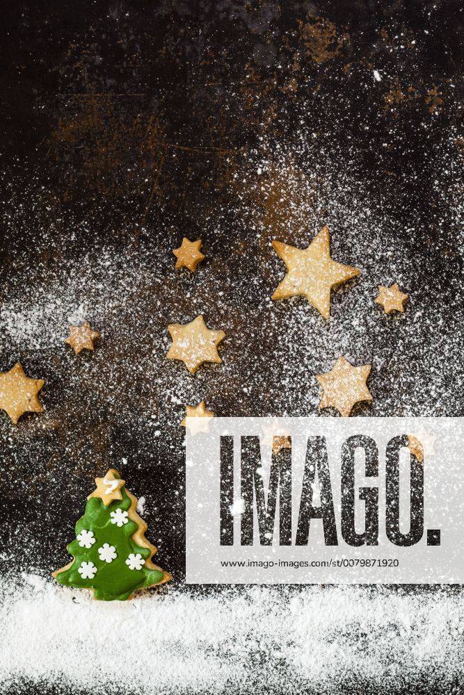 Christmas Cookies and icing sugar on baking tray SBDF03273