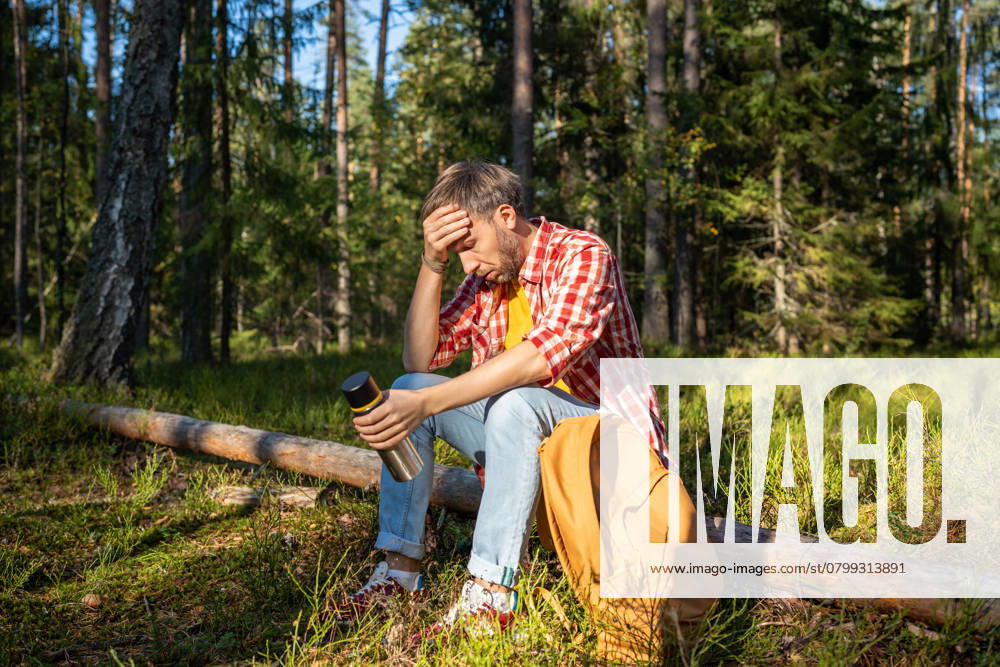 IMAGO Creative, Gesellschaft, Leisure Sickness Müder Wanderer, der eine Pause in den Bergen macht und sich schlecht fühlt, weil er auf einem Baumstamm im Wald sitzt. Müder Wanderer, der eine Pause in den Bergen macht und sich schlecht fühlt, weil er auf einem Baumstamm im Wald sitzt. ,model released, Symbolfoto