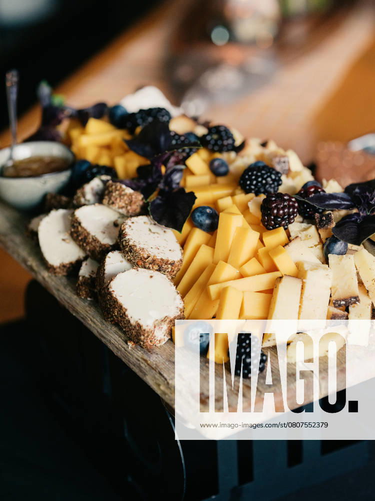 Rustic cheese board with aged cheeses, berries, and nuts on a wo United States, Colorado, Denver R_FBJQ250320B-1682907-01