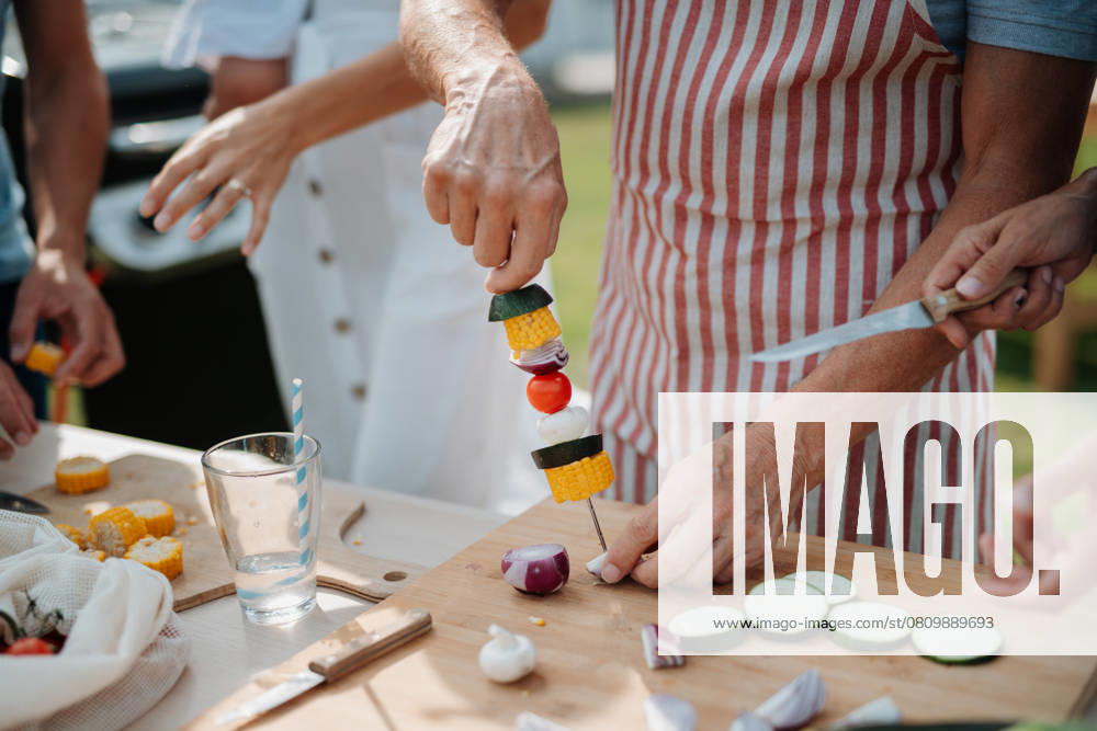 Close up of family preparing food for a spring weekend barbecue. Close up of family preparing food for a spring weekend barbecue. Garden party. model released