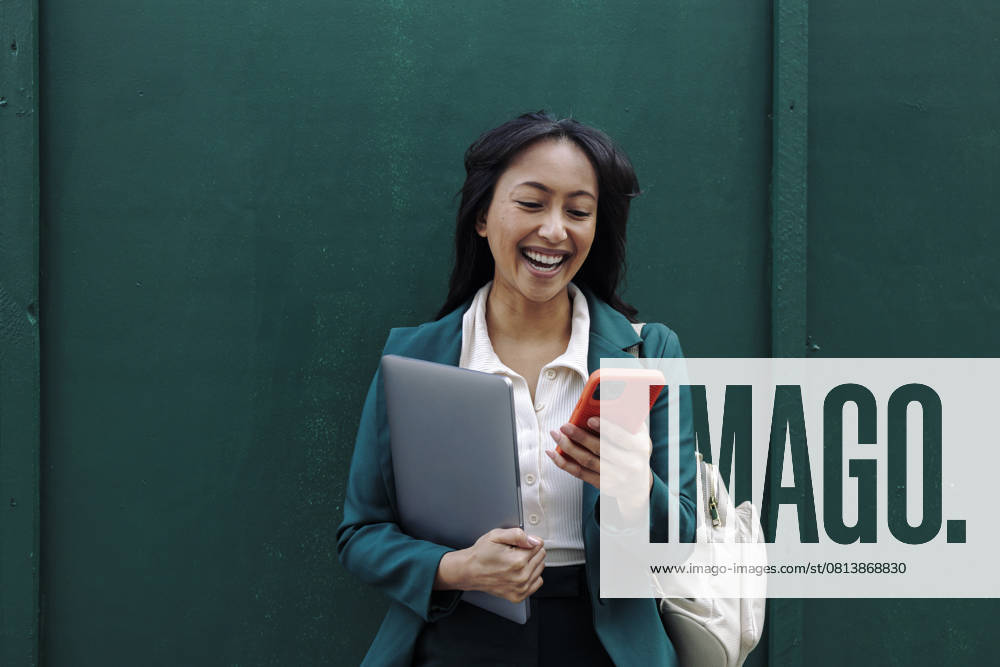 Businesswoman smiling while using smartphone outdoors model released, Symbolfoto, ASGF06292