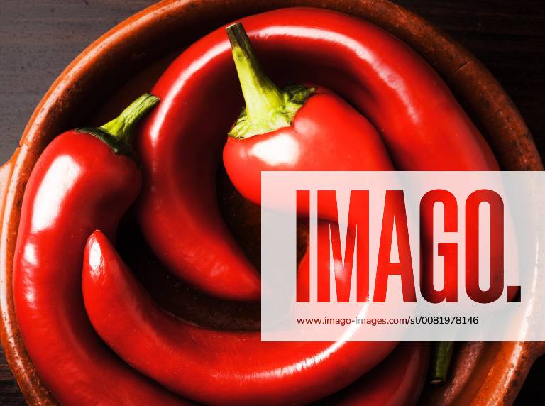 3. bent bell peppers in a bowl 3 crooked peppers bell peppers in a bowl on dark background 1028900630