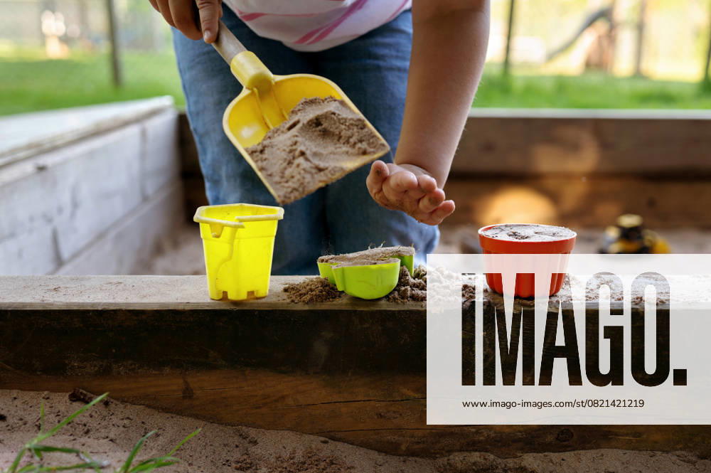IMAGO Creative, Sommer, Sommertage im Garten Child playing in sandbox with toy buckets and shovel. Corby, England, United Kingdom R_JNDO250603B-1745573-01 ,model released, Symbolfoto