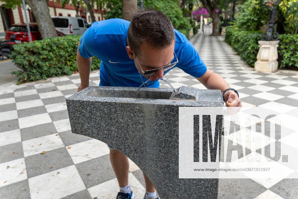 IMAGO Creative, Jahreszeit Sommer, Hitze Cadiz, Andalusia, Spain - June 9, 2025: A young man bends over and drinks directly from a public water dispenser in the city of Cadiz. In the hot summer months, access to free drinking water in public spaces is an important contribution to preventive healthcare, especially during heatwaves in southern Spain
