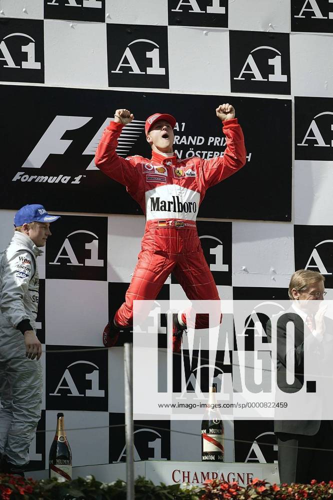 Michael Schumacher (Deutschland Ferrari, Mitte ) feiert mit einem Jubelsprung seinen Sieg, daneben: Bundeskanzler Dr. Wolfgang Schüssel (ÖVP Österreich, re.) und Kimi Räikkönen (Finnland McLaren-Mercedes) Motorsport Grand Prix Herren Großer Preis von Österreich 2003, Formel 1 Weltmeisterschaft, F1, F, GP, WM, Vdig Gruppe A1- Ring Zeltweg-Spielberg Höhe, Freude, Begeisterung,