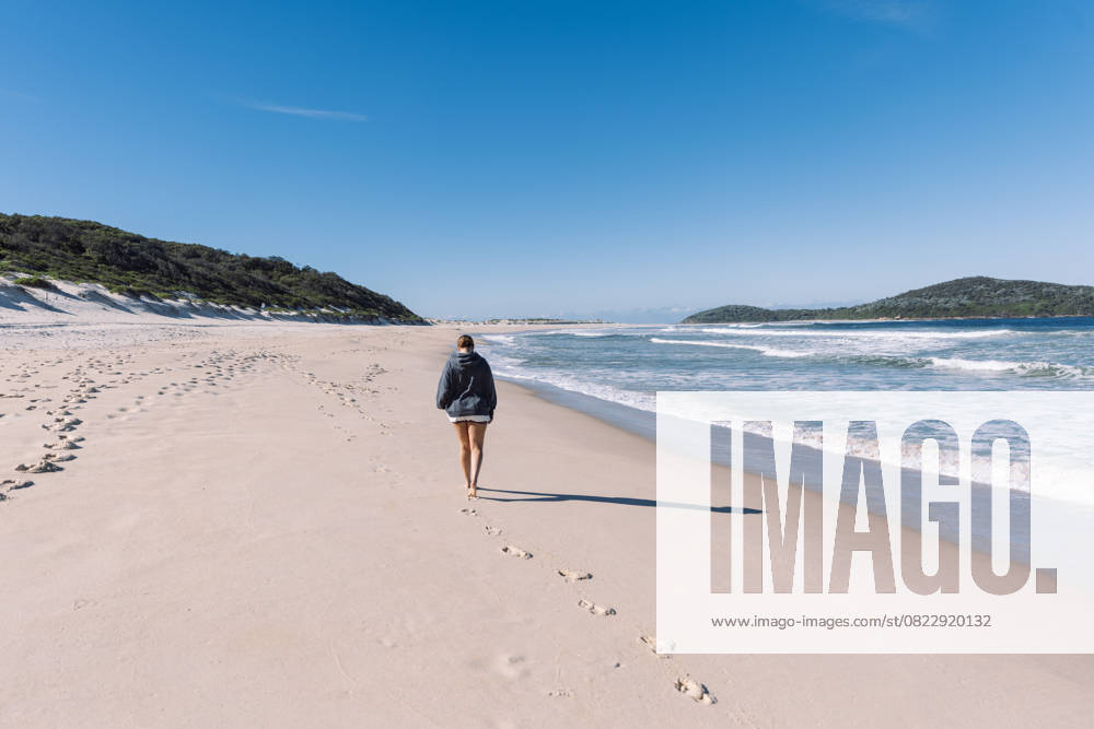Tourist walking on the beach leaving footprints in the sand Fingal Bay, New South Wales, Australia CR_MGTP250620FD-1759707-01 ,model released, Symbolfoto