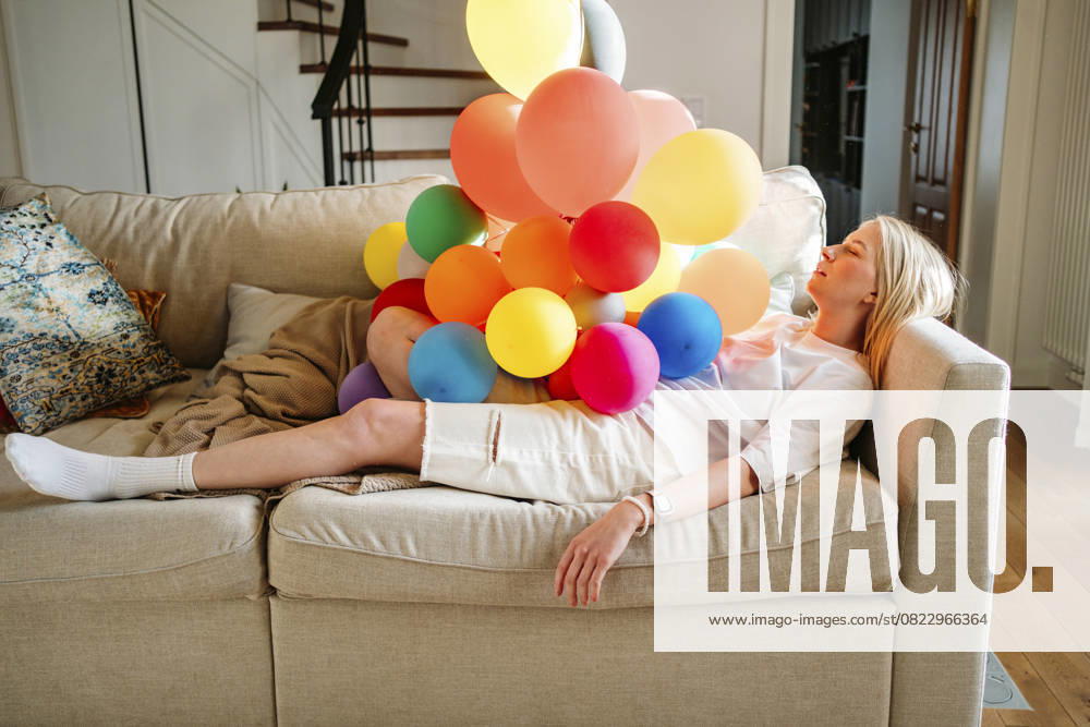 IMAGO Creative, Gesellschaft, Leisure Sickness Girl resting on a couch with colorful balloons in a living room model released, Symbolfoto property released, MDOF02884